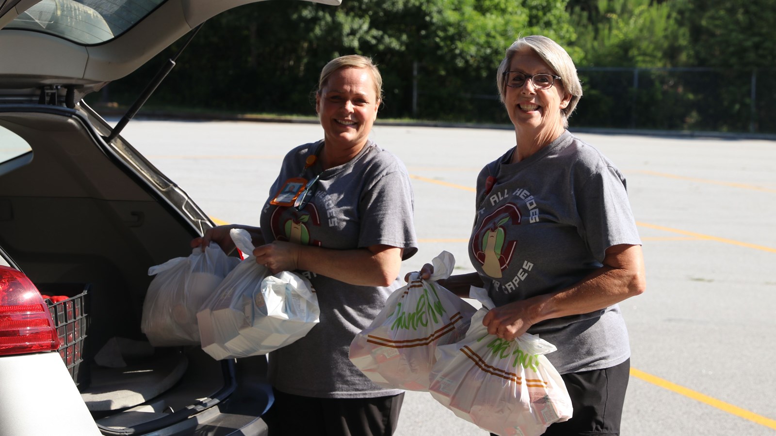 Cobb staff members load meal kits into car of Cobb parent